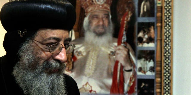 FILE - In this Sunday, Nov. 4, 2012 file photo, Bishop Tawadros, 60, soon to be Pope Tawadros II greets well-wishers, not shown, after being named the 118th Coptic Pope in the Wadi Natrun Monastery complex northwest of Cairo, Egypt. Egypt's Coptic Christian pope has sharply criticized the country's Islamist leadership in an interview with The Associated Press, Tuesday, Feb. 5, 2013, saying the new constitution is discriminatory and that Christians should not be treated as a minority. Pope Tawadros II also dismisses calls by President Mohammed Morsi for a national dialogue, saying, “We will actively take part in any national dialogue that would benefit the nation, but when a dialogue ends before it starts and none of its results are implemented then we do not take part.” (AP Photo/Roger Anis, El Shorouk Newspaper, File) EGYPT OUT