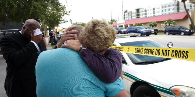 Terry DeCarlo, executive director of the LGBT Center of Central Florida, center, is comforted by Orlando City Commissioner Patty Sheehan, right, after a shooting involving multiple fatalities at a nightclub in Orlando, Fla., Sunday, June 12, 2016. (AP Photo/Phelan M. Ebenhack)