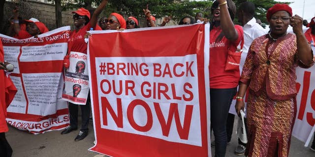 FILE - In this file photo taken Tuesday, Oct. 14, 2014, people demonstrate calling on the Nigerian government to rescue girls taken from a secondary school in Chibok region, in the city of Abuja, Nigeria. There is cautious optimism in Nigeria, Monday, Oct. 20, 2014 over local reports that the more than 200 abducted Nigerian schoolgirls may soon be released soon as part of a cease-fire agreement with the country’s Islamic rebels, Boko Haram. (AP Photo/Olamikan Gbemiga, File)