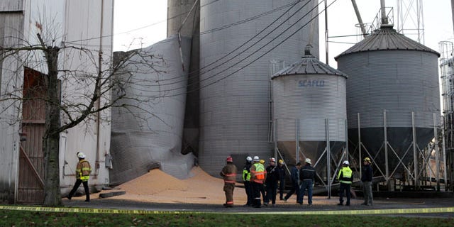 December 2, 2013: Emergency responders from the South Pierce Fire Department respond to a grain processing feed mill owned by Wilcox Farms in downtown Roy, Wash., after one of its silos collapsed. (AP Photo/The Olympian)