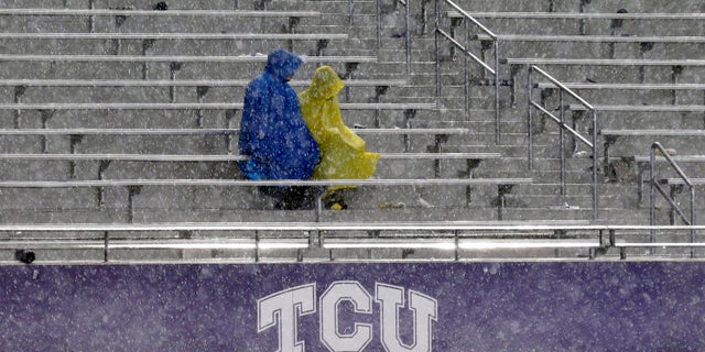 Fans sit in the stands during a thunder delay in the second quarter of an NCAA college football game between Texas and TCU, Saturday, Oct. 26, 2013, in Fort Worth, Texas. (Associated Press)