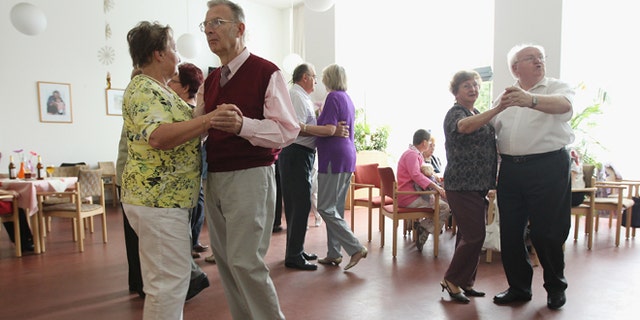 Elderly people dance during an afternoon get-together in the community room of the Sewanstrasse senior care home in Lichtenberg district on August 30, 2011 in Berlin, Germany.