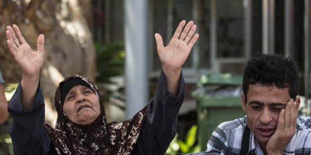 Mazoza Allan , left, and Amid Allan, a brother of Mohammed Allan, a Palestinian prisoner on a hunger strike, wait outside Barzilai hospital in Ashkelon, southern, Israel, Wednesday, August 19, 2015. Israel's Supreme Court is hearing a petition to immediately release Allan who has been on a hunger strike for 65 days. Allan's lawyer says the state has proposed a compromise under which Allan would be released in November, if he agrees to end his hunger strike. (AP Photo/Tsafrir Abayov)