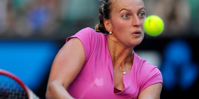 Petra Kvitova of the Czech Republic returns to Luksika Kumkhum of Thailand during their first round match at the Australian Open tennis championship in Melbourne, Australia, Monday, Jan. 13, 2014. (AP Photo/Andrew Brownbill)