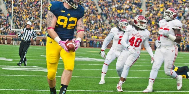 Indiana quarterback Zander Diamont (12) escapes a tackle while rushing with the ball in the third quarter of an NCAA college football game against Michigan in Ann Arbor, Mich., Saturday, Nov. 1, 2014. Michigan won 34-10. (AP Photo/Tony Ding)