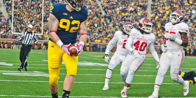 Indiana quarterback Zander Diamont (12) escapes a tackle while rushing with the ball in the third quarter of an NCAA college football game against Michigan in Ann Arbor, Mich., Saturday, Nov. 1, 2014. Michigan won 34-10. (AP Photo/Tony Ding)