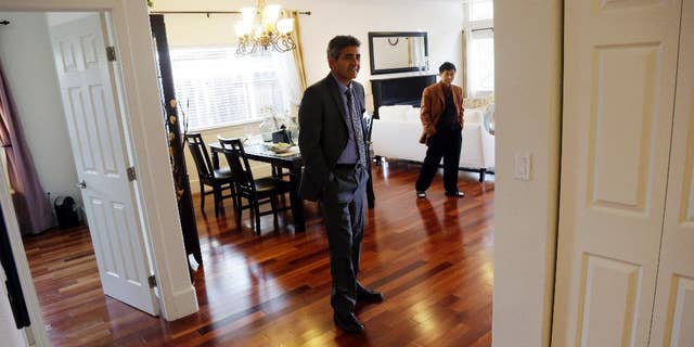 In this Jan. 8, 2015 photo, real estate agent Sam Golkar, left, tours a home being sold by fellow agent Frank Ruan, right, in Cupertino, Calif. The National Association of Realtors reports on sales of existing homes in December on Friday, Jan. 23, 2015. (AP Photo/Marcio Jose Sanchez)