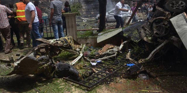 FILE - In this Tuesday, May 3, 2016, file photo released by the Syrian official news agency SANA, Syrian citizens and firefighters gather at the scene where one of rockets hit the Dubeet hospital in the central neighborhood of Muhafaza in Aleppo, Syria. A fragile cease-fire in the northern Syrian city of Aleppo has been extended for 72 hours, Russia said, as the Islamic State group battled other militant factions near the city on Saturday. (SANA via AP)