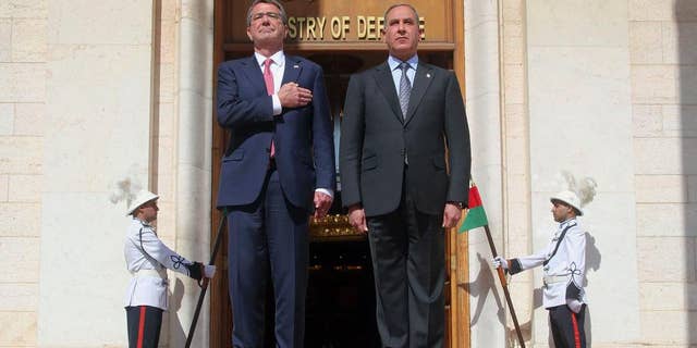 FILE - In this Monday, April 18, 2016 file photo, visiting U.S. Defense Secretary Ash Carter, left, and his Iraqi counterpart, Khaled al-Obeidi, stand for their country's national anthems during a welcome ceremony at the Ministry of Defense in Baghdad, Iraq. On Saturday, Dec. 3, 2016, Carter said the American military, along with its international partners, will need to remain in Iraq even after the expected defeat of the Islamic State group. (AP Photo)