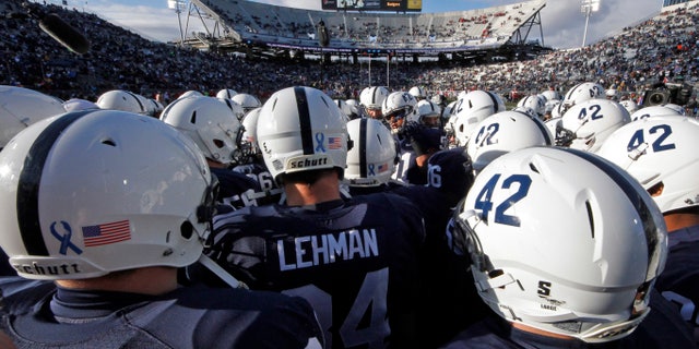 FILE - In this Nov. 24, 2012, file photo Penn State players huddle on the field before an NCAA college football game against Wisconsin in State College, Pa. Penn State said about 90 percent of the $7.8 million decline in revenue for the athletic department was due to a loss of one-time fees related to football season-ticket renewals that were not budgeted for in 2012. (AP Photo/Gene J. Puskar, File)