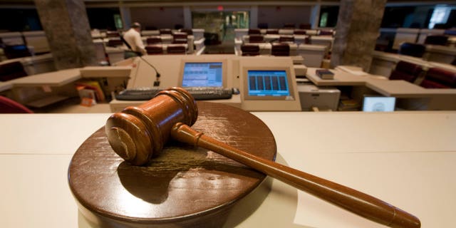 The gavel stands ready as Alabama House Public Information Officer Clay Redden, rear, makes preparations House chamber in Montgomery, Ala., on Friday, Dec. 3, 2010 a for the special session on ethics legislation called by Gov. Bob Riley. The lawmakers come into session next Wednesday. (AP Photo/Dave Martin)