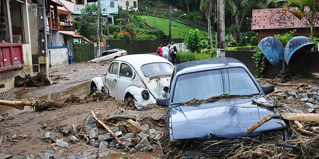 Jan. 12: Cars sit in debris in a flooded street in Teresopolis, Rio de Janeiro state, Brazil.