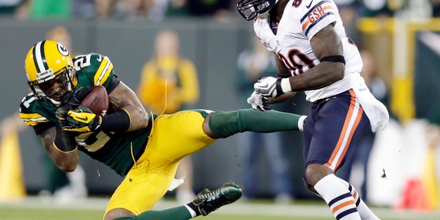 FILE - In this Sept. 13, 2012, file photom, Green Bay Packers' Charles Woodson intercepts a pass in front of Chicago Bears' Earl Bennett (80) during the second half of an NFL football game in Green Bay, Wis. Woodson signed a one-year contract with the Oakland Raiders on Tuesday, may 21, 2013, to return to his original team after leaving seven years ago for Green Bay as a free agent. The 36-year-old was released by the Packers in a salary-cutting move Feb. 15, with two years remaining on his contract. (AP Photo/Morry Gash, File)