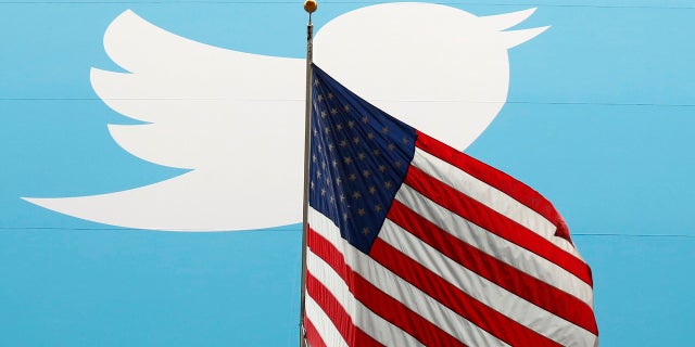 The Twitter Inc. logo is shown with the U.S. flag during the company's IPO on the floor of the New York Stock Exchange in New York, Nov. 7, 2013.