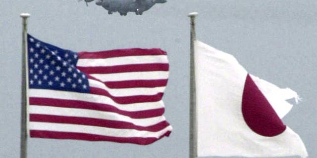 In this Sept. 23, 2001 photo, flags of U.S. and Japan flutter in U.S. Kadena Air Base on the southern island of Okinawa in Japan. An American sailor has tapped a cloud-based technology for mobile phones to make it easier to have volunteers take turns driving drunk friends home, an initiative that has curtailed drunken driving among the Navy ranks. The effort, tested at the Naval Sea Systems Command in Charleston, South Carolina, from February, 2016 could also help ease tensions on the southwestern Japanese island of Okinawa, where most of the U.S. troops in Japan are assigned. (Kyodo News via AP) JAPAN OUT, CREDIT MANDATORY