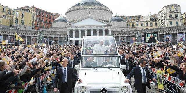 In this March 21, 2015 pool photo, made available Monday, March 23, 2015, Pope Francis, center, is cheered by faithful as he arrives with his popemobile to celebrate a Mass, in Naples, Italy. Pope Francis made an impassioned defense of the unemployed during a speech to people in the poor Neapolitan neighborhood of Scampia Saturday. (AP Photo/L'Osservatore Romano, Pool)