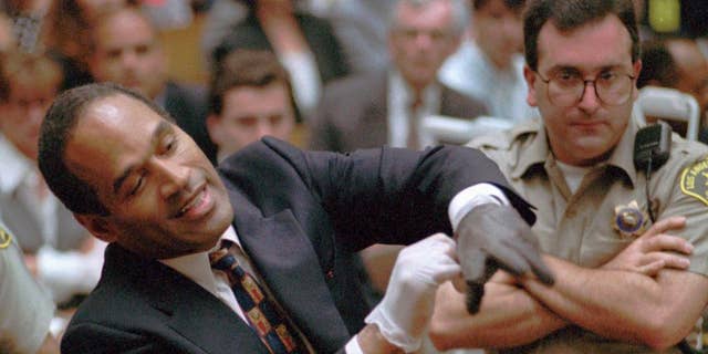 In this June 15, 1995, file photo, murder defendant, O.J. Simpson grimaces as he tries on one of the leather gloves prosecutors say he wore the night his ex-wife Nicole Brown Simpson and Ron Goldman were murdered, during the Simpson double-murder trial in Los Angeles.