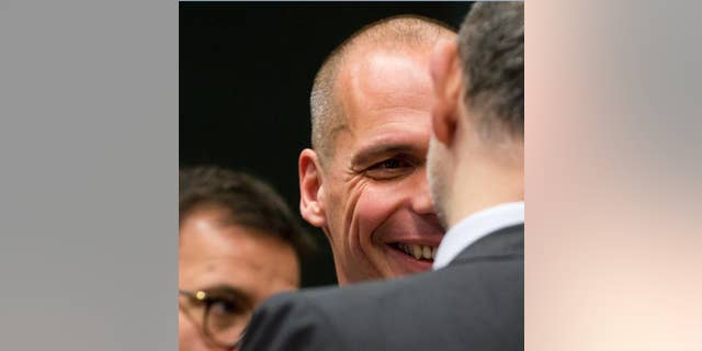 Greek Finance Minister Yanis Varoufakis, center, speaks with European Commissioner for the Economy Pierre Moscovici, right, during a meeting of the eurogroup finance ministers at the EU Council building in Brussels on Monday, May 11, 2015. Hopes for a deal between Greece and its European creditors at a key meeting Monday are slim, weighing on the region's stock markets as the country struggles to make upcoming debt repayments. (AP Photo/Virginia Mayo)