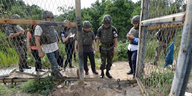 FILE - In this Aug. 9, 2015 file photo provided by the Defense Ministry, an unidentified South Korean army official, second from right, gives a briefing to the media at the scene of a blast inside the demilitarized zone in Paju, South Korea. North Korea insisted Tuesday, Sept. 1, 2015 that its recent expression of “regret” over a mine explosion that maimed two South Korean soldiers was not an apology, as Seoul claims it was. (The Defense Ministry via AP, FIle)