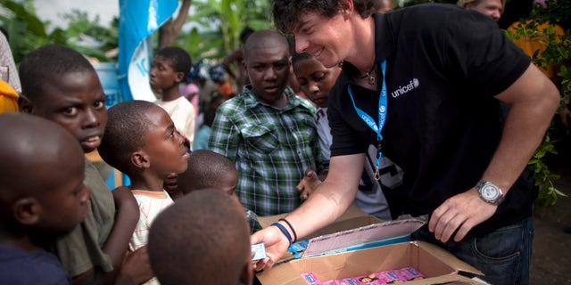 June 6, 2011: Rory McIlroy distributes bars of soap to children at a kindergarten run by UNICEF in Port-au-Prince, Haiti. (AP)