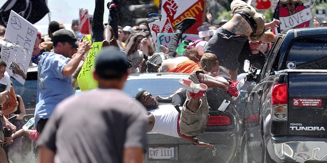 People fly into the air as a vehicle drives into a group of protesters demonstrating against a white nationalist rally in Charlottesville, Va., Saturday, Aug. 12, 2017.