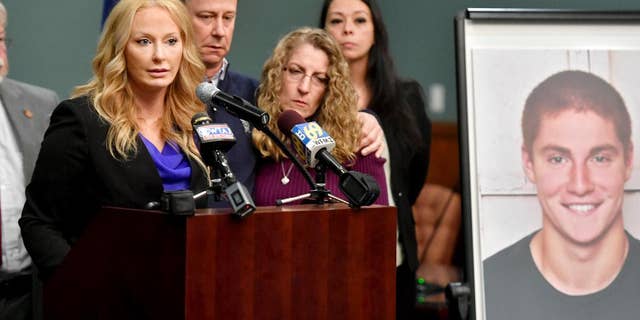 Jim and Evelyn Piazza stand by as Centre County District Attorney Stacy Parks Miller, left, announces the results of an investigation into the death of their son Timothy Piazza, seen in photo at right, a Penn State University fraternity pledge, during a press conference Friday, May 5, 2017, in Bellefonte, Pa. Timothy Piazza had toxic levels of alcohol in his body and was badly injured in a series of falls, authorities said Friday in announcing criminal charges against members of the organization and the frat itself. (Abby Drey/Centre Daily Times via AP)