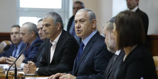 Israel's Prime Minister Benjamin Netanyahu, center, speaks during the weekly cabinet meeting in Jerusalem, Sunday, Dec. 13, 2015. (Baz Ratner/Pool Photo via AP)