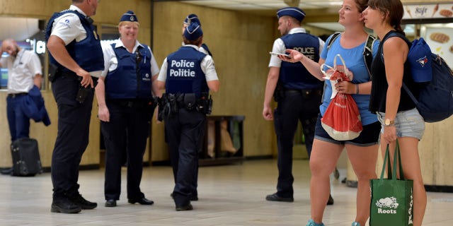 Belgian police officers stand guard in central station in Brussels, Belgium
