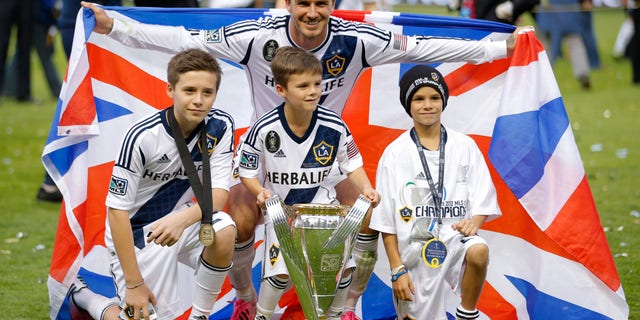FILE - In this Saturday, Dec. 1, 2012 file photo Los Angeles Galaxy's David Beckham, top center, of England, poses with his sons, from left, Brooklyn, Romeo and Cruz after the Galaxy's 3-1 win in the MLS Cup championship soccer match against the Houston Dynamo in Carson, Calif. David Beckham's eldest son just might be the next person in his family to play in the Premier League. Brooklyn Beckham, the oldest of Beckham's four children at 13, is having a trial with London club Chelsea and played in an under-14 game on Tuesday at the team's training base, people familiar with the situation told The Associated Press. (AP Photo/Jae C. Hong)