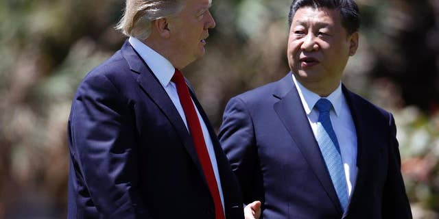 FILE - In this April 7, 2017 file photo, President Donald Trump, left, and Chinese President Xi Jinping walk together after their meetings at Mar-a-Lago, in Palm Beach, Fla. Trump has praised Xi since hosting him at his Palm Beach, Fla., resort, after sharply criticizing China’s economic policies as a candidate. Since taking office, Trump has displayed a striking willingness to embrace autocrats as potential partners in his “America First” agenda, even if it means ignoring their heavy-handed tactics and repression at home. (AP Photo/Alex Brandon, File)