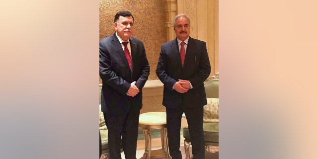 In this Tuesday, May 2, 2017, photo supplied by the Libyan armed forces, Tripoli-based Prime Minister Fayez Serraj, left, poses for a photograph with Field Marshal Khalifa Hifter, right, in Abu Dhabi, United Arab Emirates. The two met Tuesday in the UAE capital for what the Libyan military described as "Arab and international mediation" over that country's long political crisis. (Libyan armed forces via AP)