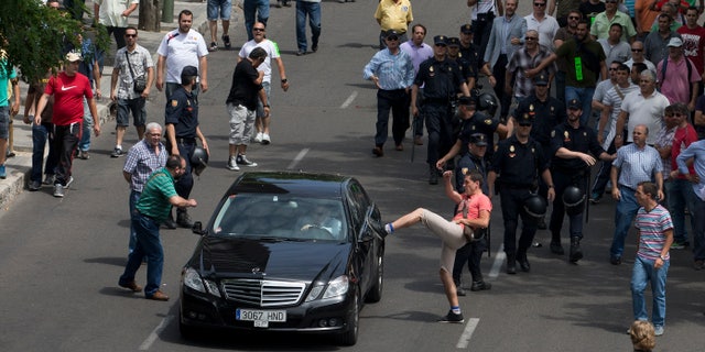 A demonstrator kicks a car during a taxi strike and protest in Madrid, Spain, in June 2014