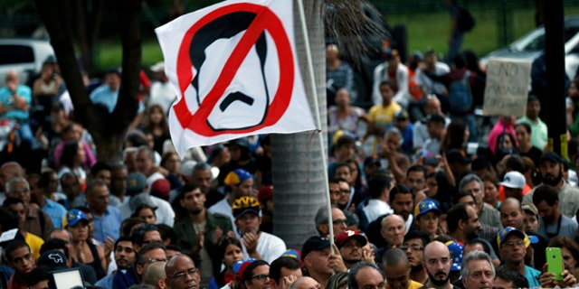 An anti-government demonstrator waves a flag against Venezuela's President Nicolas Maduro, in Caracas, Venezuela, July 31, 2017.