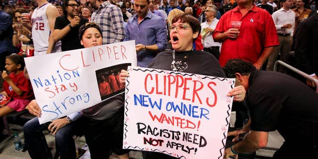 Fans hold up signs in support of the Los Angeles Clippers before Game 5 of an opening-round NBA basketball playoff series between the Clippers and the Golden State Warriors on Tuesday, April 29, 2014, in Los Angeles. NBA Commissioner Adam Silver announced Tuesday that Clippers owner Donald Sterling has been banned for life by the league. (AP Photo/Ringo H.W. Chiu)