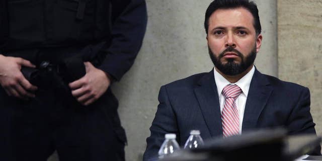 FILE - In this April 20, 2015, file photo, Chicago Police Detective Dante Servin listens as Judge Dennis Porter reads his decision at the Leighton Criminal Court Building in Chicago on involuntary manslaughter charges in the March 2012 shooting death of Rekia Boyd. Servin, whom the department was trying to fire after he fatally shot Boyd, has decided to resign from the force rather than fight to retain his job. (John J. Kim/Chicago Tribune via AP, Pool)