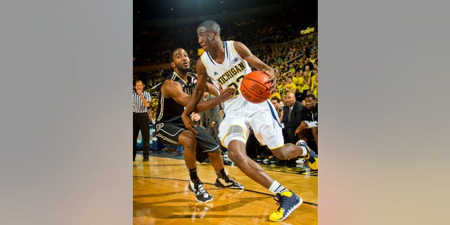 Purdue guard Rapheal Davis, left, defends Michigan guard Caris LeVert (23) in the first half of an NCAA college basketball game in Ann Arbor, Mich., Thursday, Jan. 30, 2014. (AP Photo/Tony Ding)