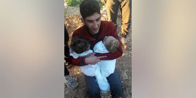 Abdul-Hamid Alyousef, 29, cries as he holds his twin babies who were killed.