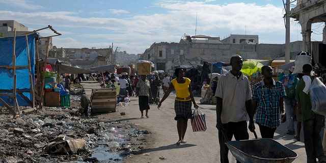 Haitians walk on a badly damaged street almost two years after the devastating January 12, 2010 earthquake that killed more than 200,000 people in Port-au-Prince December 28, 2011.