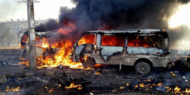 This Sunday, Dec. 15, 2013 citizen journalism image provided by Aleppo Media Center AMC, which has been authenticated based on its contents and other AP reporting, shows flames rising from burning vehicles following a Syrian government airstrike in Aleppo, Syria. The Britain based Syrian Observatory for Human Rights said Monday that dozens of children were among the scores killed in airstrikes on several opposition areas a day earlier. (AP Photo/Aleppo Media Center, AMC)