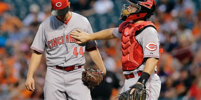 Cincinnati Reds catcher Tucker Barnhart, right, pats starting pitcher Mike Leake on the chest during a visit to the mound after Leake walked Baltimore Orioles' J.J. Hardy in the first inning of an interleague baseball game, Thursday, Sept. 4, 2014, in Baltimore. Baltimore scored six runs in the first. (AP Photo/Patrick Semansky)