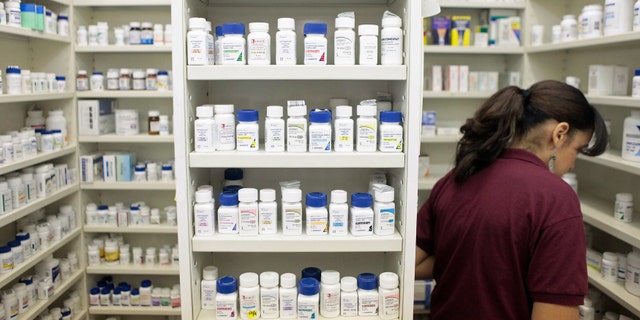 A pharmacy employee looks for medication as she works to fill a prescription while working at a pharmacy in New York December 23, 2009. REUTERS/Lucas Jackson (UNITED STATES - Tags: HEALTH POLITICS) - RTR28BCM