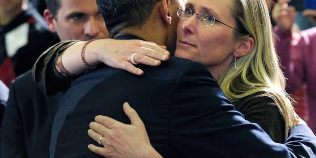 FILE - In this April 8, 2013, file photo, President Barack Obama embraces Scarlett Lewis, mother of Sandy Hook Elementary School shooting victim Jesse Lewis, after speaking at in Hartford, Conn. Through his death in a gun battle with police on Sunday, June 12, 2016, the Orlando nightclub gunman deprived his victims' families of the chance for a trial that could have helped to channel grief, offer a sense of justice or provide answers for the bloodshed. In Newtown, Conn., where the gunman took his own life after killing 26 people inside the school in December 2012, Lewis said his survival only would have made it more difficult as she grieved for her murdered son, Jesse. (AP Photo/Susan Walsh, File)