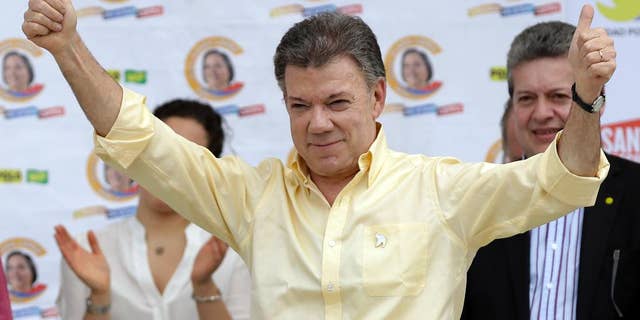 FILE - In this June 5, 2014 file photo, Colombia's President Juan Manuel Santos gives a thumbs up during a campaign event in Bogota, Colombia. A corruption scandal that has spread across Latin America is inching closer to Santos amid new evidence on Monday, March 6, 2017 that suggests a Brazilian construction company paid $1 million for an opinion poll carried out during his re-election campaign. (AP Photo/Fernando Vergara, File)