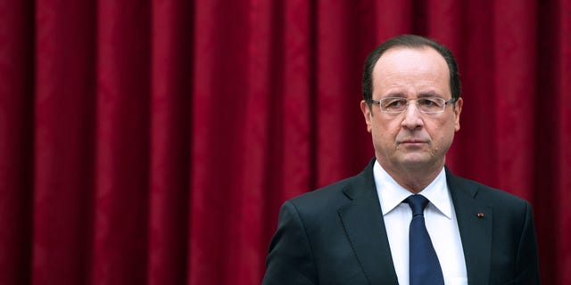 France's President Francois Hollande arrives to deliver a speech to ministers and members of the White Book of Defense and National Security committee at the Elysee presidential palace in Paris, Monday April 29, 2013. France said Monday it will cut another 24,000 military jobs by 2019 as it attempts to maintain a force ready to deal with global threats at the time when the bill for France's decades of deficit spending is due. (AP Photo/Bertrand Langlois, Pool)