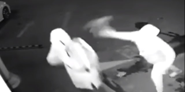 The following screen grab is from a video released by the Shanghai Police Department that shows two unidentified men attempting to break into a storefront window.
