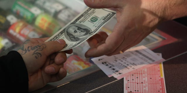 CHICAGO, IL - NOVEMBER 28: A customer purchases a Powerball lottery ticket at a 7-Eleven store on November 28, 2012 in Chicago, Illinois. Jim Bayci, who owns the store, estimates more than half of his customers included at least one Powerball ticket with their purchase today. The jackpot for Wednesday's Powerball drawing is currently at $550 million which is the richest Powerball pot ever. It is likely to rise even more as people continue to buy before tonights drawing. (Photo by Scott Olson/Getty Images)