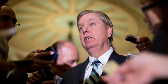 FILE - In this Oct. 16, 2013, file photo, Sen. Lindsey Graham, R-S.C., speaks with reporters on Capitol Hill in Washington. Graham threatened Monday, Oct. 28, to hold up all nominations for federal government positions until survivors of last year's deadly attack on the diplomatic post in Libya appear before Congress. (AP Photo/Carolyn Kaster, File)