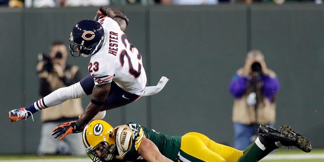 Chicago Bears player Devin Hester (23) is tackled by Green Bay Packer John Kuhn on a punt return during the second half of an NFL football game Thursday, Sept. 13, 2012, in Green Bay, Wisconsin.