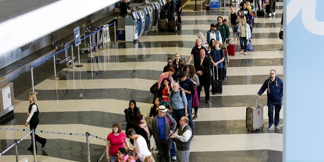 File-This May 16, 2016, file photo shows a long line of travelers waiting for the TSA security check point at O'Hare International airport, in Chicago. As airport security lines get longer, the finger-pointing over blame is growing too. The nation's leading airlines, already feuding with the Transportation Security Administration, are now taking on Congress. The trade group Airlines for America on Thursday, May 19, 2016, says Congress should reverse a 2013 decision that diverted $12.6 billion in passenger-security fees to reducing the federal budget deficit. The airlines want that money to pay for airport security screening. (AP Photo/Teresa Crawford)