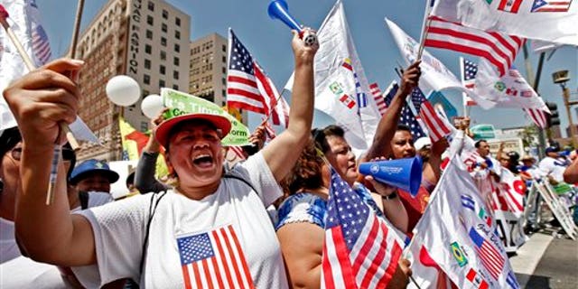 Alma Banuelos, left, with Emilia Hernandez shout slogans during a rally in downtown Los Angeles Wednesday, May 1, 2013. In celebration of May Day thousands have gathered for an immigration reform rally in downtown Los Angeles. (AP Photo/Nick Ut)